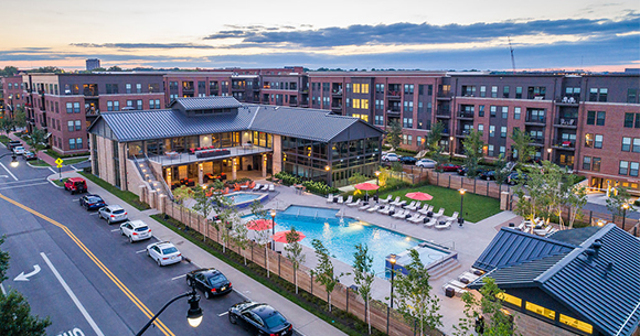 aerial view of apartment community center and outdoor pool at dusk